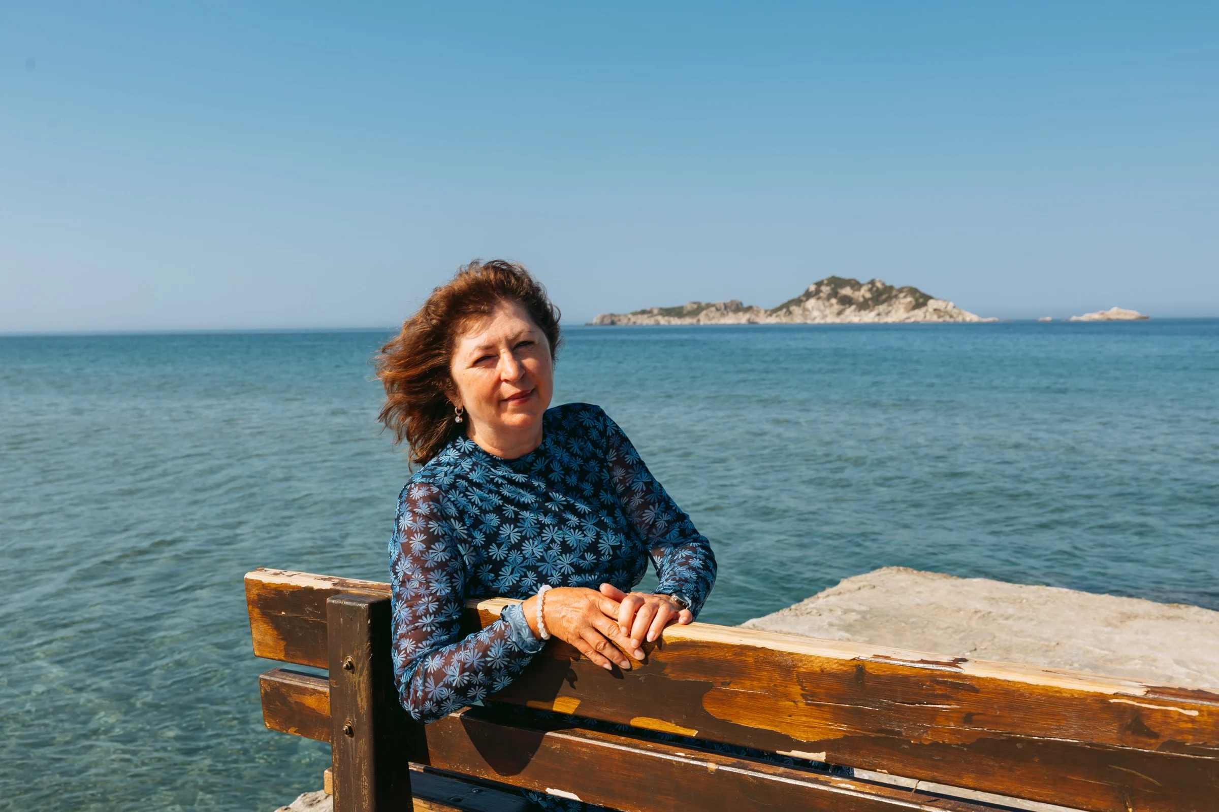 Olga Westerveld an einer Holzbank am Meer